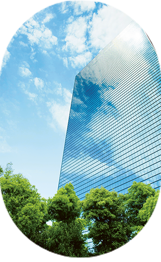 Glasfront eines Gebäudes mit blauem Himmel und Grünfläche